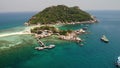 Boats and pier near small islands. Motor dive boats floating on calm blue sea near unique small islets connected with beaches and