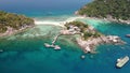 Boats and pier near small islands. Motor dive boats floating on calm blue sea near unique small islets connected with beaches and