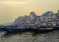 Boats at river Ganga Ghat people at holy ghats among ancient hindu temples in early morning in Varanasi Evening at Banaras Ghat