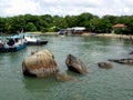 Boats and rocks on a beach in Pulau Ubin, Singapore