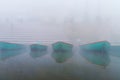 Boats on sacred river Ganges at cold foggy winter morning. Varanasi Royalty Free Stock Photo