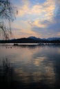 Boats sailing on the calm sea in the background with mountains at sunset. Dramatic sky. Royalty Free Stock Photo