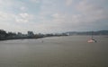 Boats sailing on the Chone river with a panoramic view of the city in the background during sunset