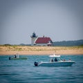 Boats in the sea with Race Point Lighthouse in the background. Provincetown, Massachusetts, US.