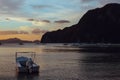 Boats in the sea at sunset. White boat on big mountain background.  Philippines isles. Fishing boat at sunset. Royalty Free Stock Photo