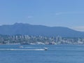 Boats and ships in the sea in front of a big city and mountains Royalty Free Stock Photo