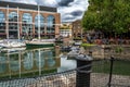 Boats And Ships In St Katharine Docks With Office Buildings And Restaurants In London, UK