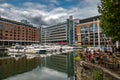 Boats And Ships In St Katharine Docks With Office Buildings And Restaurants In London, UK