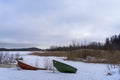 Boats on the shore of a frozen lake in Finland. Winter landscape, copy space Royalty Free Stock Photo