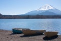 Boats at the shore of Saiko Lake in Japan in early spring, Mt Fuji in the background