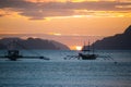 Boats silhouette in the sea on sunset and isles background. Traditional Philippines fishing boat at sunset. Royalty Free Stock Photo