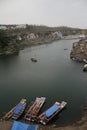 Boats and a small pedestrian bridge on the ghats of narmada river in the holy city of omkareshwar madhya pradesh India