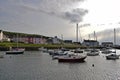 Boats moored in the harbour with the different coloured brightly coloured houses in the background in Wales