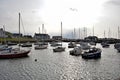 Boats moored in the harbour with the different coloured brightly coloured houses in the background in Wales