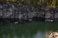 Boats with tourists float on the lake of the Great Marble Canyon in the Republic of Karelia in Russia