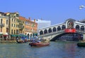 Boats travel under Rialto bridge Venice