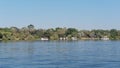 Boats traveling on the water near trees and bushes, Zambezi River near Victoria Falls, Zimbabwe Royalty Free Stock Photo