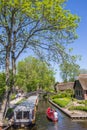 Boats, wooden bridges and old houses at the water in Giethoorn