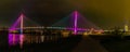 Panorama of Bob Kerrey pedestrian bridge Omaha Nebraska at night with multiple light reflections in the Missouri river.