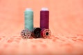 Bobbin case, two bobbin and two sewing thread on the orange cloth Royalty Free Stock Photo