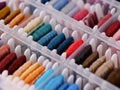 Bobbins with different colour embroidery threads in a plastic sorting box. Royalty Free Stock Photo
