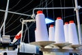 Bobbins with white threads secured in an industrial sewing machine Royalty Free Stock Photo