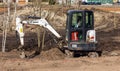 A bobcat excavator parses the ground in the park