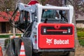 Bobcat S650 skid steer loader machine parked on the residential street during road maintenance project - San Jose, California, USA
