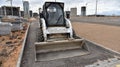 Bobcat skid-steer loader for loading and unloading works on city streets. ompact construction equipment for work in limited