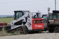 A Bobcat Skid steer loader at a work site with blue sky Royalty Free Stock Photo