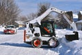 Bobcat skid steer removing snow from driveway Royalty Free Stock Photo