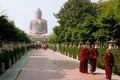 BODHGAYA, INDIA: Group of Buddhist monks walking on the alley from the huge statue of Buddha Royalty Free Stock Photo