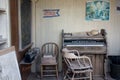 Bodie, California - Interior of the old school house, with a piano, chairs, blackboard and posters in a state of