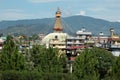 Bodnath stupa against the background of green plants, blue sky and clouds