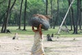 Bodos tribal old Senior Woman carry heavy bundle wood on her head walking on dirt road. Doing household duties responsibility.