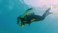 PADI diver holds her nose to equalize as she submerges