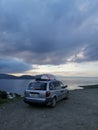 Bodrum, Turkey - 23 December 2022: A silver Dodge Caravan minivan type car with a surf on roof stands on the seashore Royalty Free Stock Photo