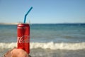 Bodrum, Turkey - SEPTEMBER 30 2020: Coca cola tin can  on waman hand on the background of the sea. Royalty Free Stock Photo