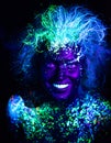 Body art and contact lenses glowing in ultraviolet light. Woman smiling, painted in fluorescent powder. Stars in the