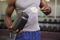 Body builder holding a scoop of protein mix in gym