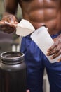 Body builder holding a scoop of protein mix