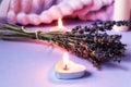 Body care with aromatic plants: burning candles against the background of a bouquet of lavender, bath towel, side view, close-up Royalty Free Stock Photo
