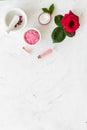 Cream, bath salt, lotion for organic cosmetics with rose flower on white marble background top view space for text Royalty Free Stock Photo