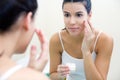 Body care. Woman applying cream on face