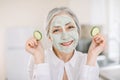 Body and face skin care, anti aging treatment. Close up horizontal shot of pretty senior woman with clay facial mask Royalty Free Stock Photo