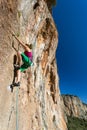 Body of female extreme Climber stepping up on high vertical Rock Royalty Free Stock Photo