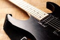 Body and fretboard of modern electric guitar on rustic wooden background. Royalty Free Stock Photo