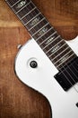 Body and fretboard of modern electric guitar on rustic wooden background. Royalty Free Stock Photo