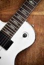 Body and fretboard of modern electric guitar on rustic wooden background. Royalty Free Stock Photo