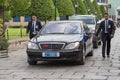 Body guards protect state automobile, which moves in the Grand Palace in Bangkok.